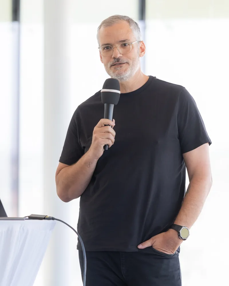 Gerald Aichholzer am Mikrofon bei einem KI-Vortrag